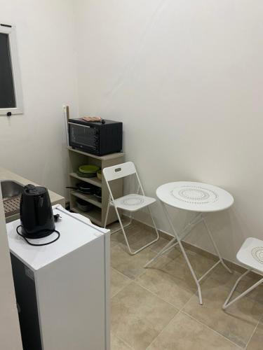 Habitación con microondas, mesa y sillas. en Wawa Estudio 3 en Posadas