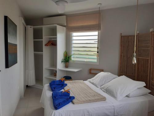 a bedroom with a bed with blue towels on it at A L'Arche Bleue in Le Robert