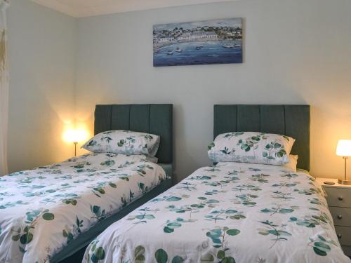 a bedroom with two beds and a painting on the wall at The Stables in Hedon