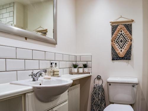 W łazience znajduje się umywalka, toaleta i lustro. w obiekcie Coopers Townhouse w mieście Worle