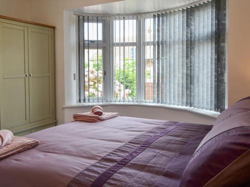 sypialnia z łóżkiem i dużym oknem w obiekcie Trinity Avenue Cottage w mieście Bridlington