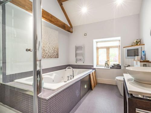 a bathroom with a tub and a sink and a toilet at Chestnut Barn in Wold Newton