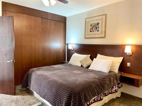 サンミゲル・デ・アジェンデにあるHermoso departamento en San Miguel De Allendeのベッドルーム1室(木製ヘッドボード付きのベッド1台付)