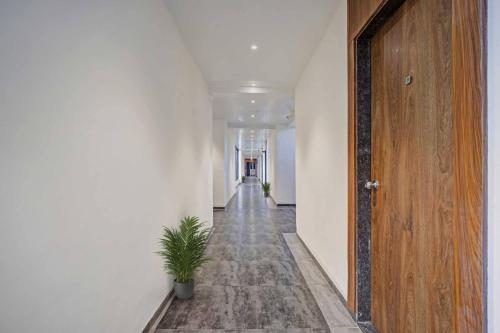 a hallway with a door and a potted plant at OYO Collection O Hotel Infini Palace in Surat