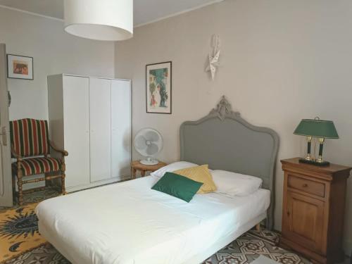 BédarridesにあるMaison de famille au cœur de Bédarridesのベッドルーム1室(緑の枕が付いたベッド1台付)