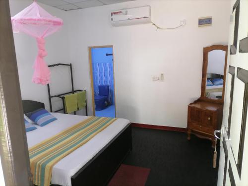 a small room with a bed and a mirror at Werala Beach Resort in Kalpitiya