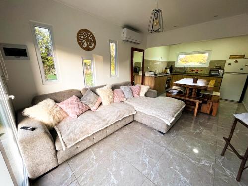ein Wohnzimmer mit Sofa und eine Küche in der Unterkunft Cabañas Maravillas de Quetroleufu in Pucón
