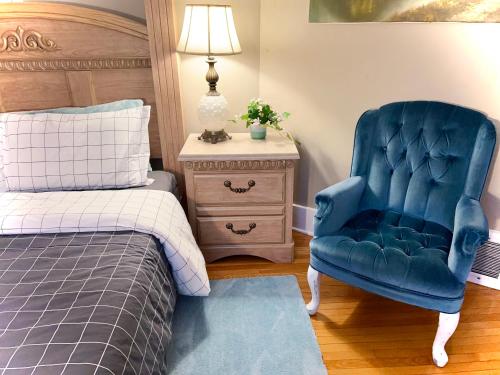 Un dormitorio con una silla azul y una cama en River view house en Winnipeg