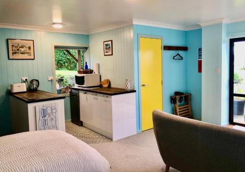cocina con encimera y puerta amarilla en Butterfield Beach Studio Car petrol and breakfast provisions included, en Half-moon Bay