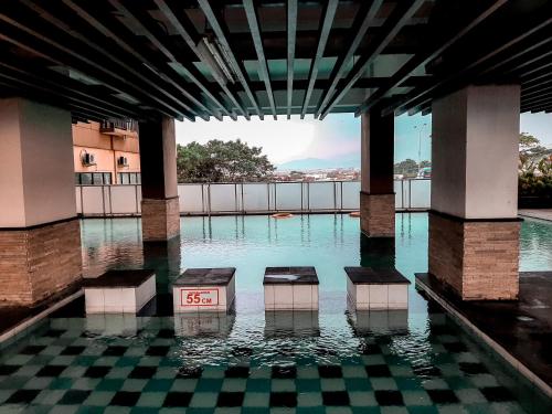 a pool of water with a clock in the middle at Apartemen Panoramic by Dio Property in Bandung