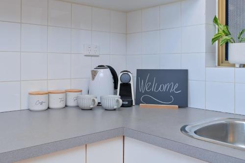 a kitchen counter with a counter top with a welcome sign at Freo Skyhighcentral With Views in Fremantle