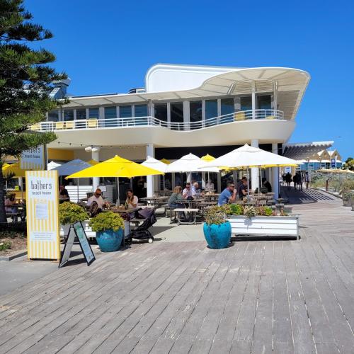a building with tables and yellow and white umbrellas at Freo Skyhighcentral With Views in Fremantle