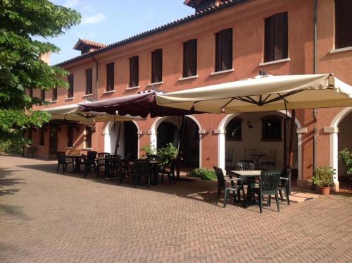 a patio with tables and umbrellas in front of a building at Agriturismo Da Ninoti in Treviso