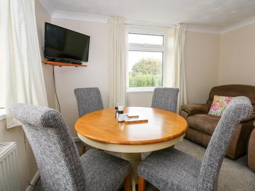 a living room with a wooden table and chairs at Sheppard's Hut in Terrington Saint Clement