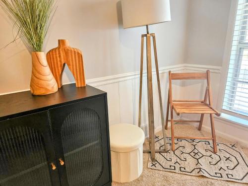 a living room with a chair and a television at VillaQuèFrancia near Elvis Presley's Graceland 6 mins from Airport, Shuttle, & Rental Vehicle in Memphis