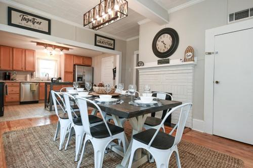 a dining room with a table and white chairs at The Bulldog Farmhouse 100 year old home in Athens