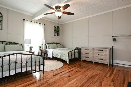 a bedroom with two beds and a ceiling fan at The Bulldog Farmhouse 100 year old home in Athens