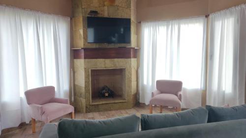a living room with a couch and a fireplace at Rincón Bonito in El Hoyo