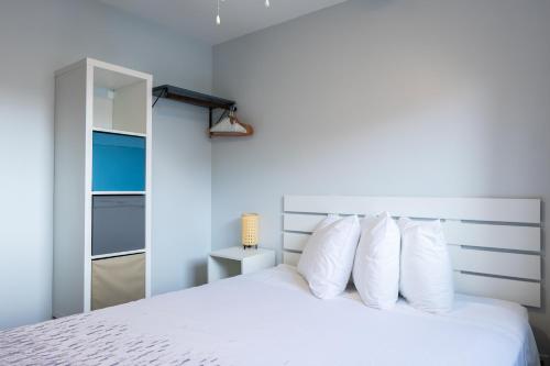 a bedroom with a white bed with white pillows at Poplars Motel on the lake in Osoyoos