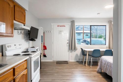 a small kitchen with a table and a bedroom at Poplars Motel on the lake in Osoyoos