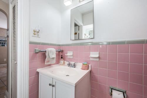 uma casa de banho rosa com um lavatório e um espelho em Blue Water Beachside villa 3 em Clearwater Beach