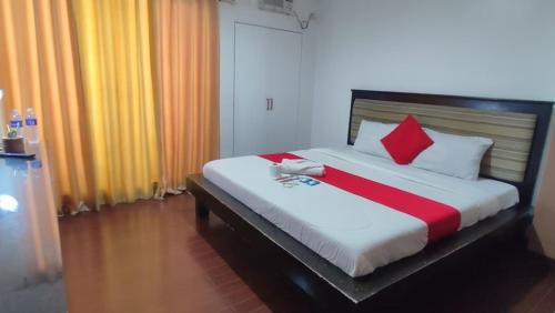 a bedroom with a bed with red and white pillows at Poblacion Bed & Breakfast by SMS Hospitality in Manila