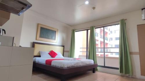 a bedroom with a bed and a large window at Poblacion Bed & Breakfast by SMS Hospitality in Manila