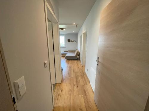 un couloir menant à une chambre avec un lit et une porte dans l'établissement Cozy Apartment near Vienna Airport, à Schwechat