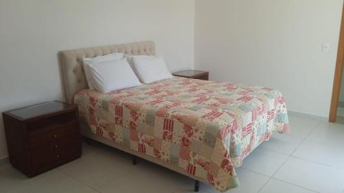 een bed met een dekbed en twee kussens erop bij Casa amarela in Niterói