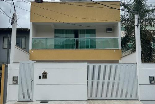 uma casa branca com um portão e uma garagem em Casa amarela em Niterói
