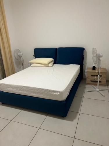 a bed with a blue bed frame in a room at Porta Palermo Centro Sciacca in Sciacca