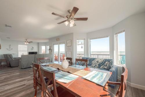a dining room and living room with a ceiling fan at Surfside Beachfront Dream in Surfside Beach