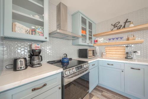 a kitchen with blue cabinets and a stove top oven at Surfside Beachfront Dream in Surfside Beach