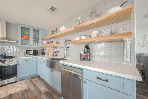 a kitchen with blue cabinets and a sink at Surfside Beachfront Dream in Surfside Beach