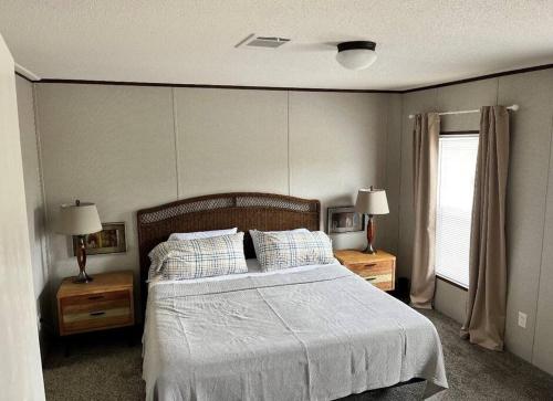 a bedroom with a bed and two night stands and a window at Ranch Road Retreat in Clermont