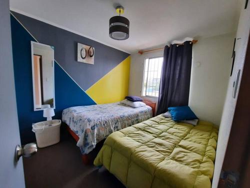 Casa acogedora sector céntrico في لا سيرينا: غرفة نوم بسريرين وجدار ازرق واصفر