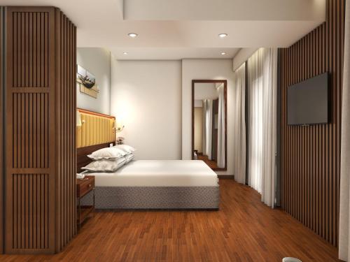 a bedroom with a white bed and a mirror at Park Inn by Radisson Goa Candolim in Candolim