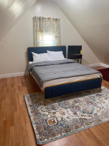 Schlafzimmer mit einem Bett mit einem Teppich und einem Fenster in der Unterkunft Cheerful New Renovated One Private Bedroom in Morris Park