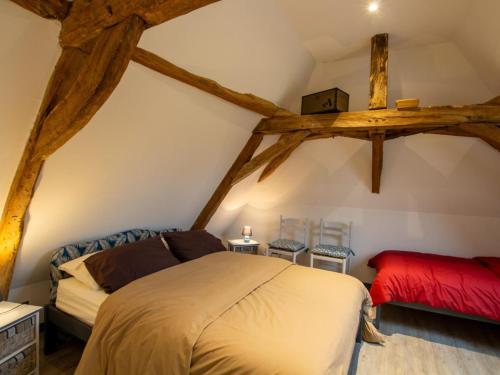 ein Schlafzimmer mit einem Bett und zwei Stühlen im Dachgeschoss in der Unterkunft Gîte Saint-Pierre-de-Chignac, 3 pièces, 6 personnes - FR-1-616-18 in Saint-Pierre-de-Chignac