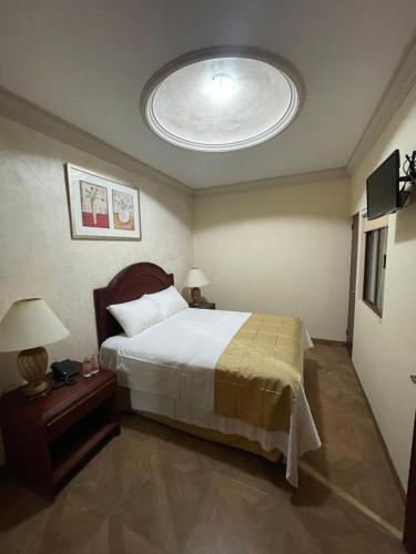 a bedroom with a large bed with a large ceiling at Hotel Plaza Express in Torreón