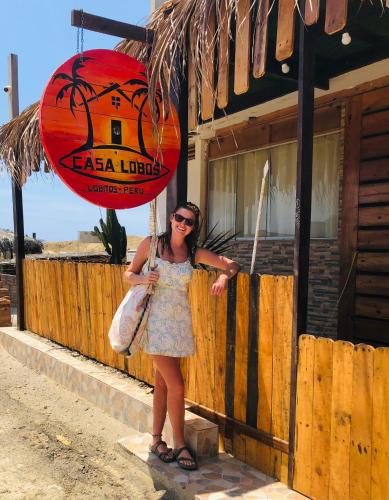 a woman standing in front of a building holding an umbrella at Casa Lobos in Lobitos