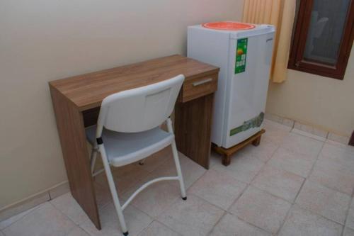 a desk with a white chair next to a refrigerator at Habitación privada y céntrica /cómoda! in Santa Cruz de la Sierra