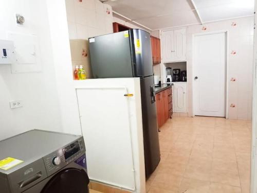 a kitchen with a refrigerator and a stove at Apartamento Estadio Laureles in Medellín