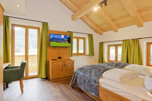 a bedroom with a bed and a television in it at Ferienhof Oberhuber in Staudach-Egerndach