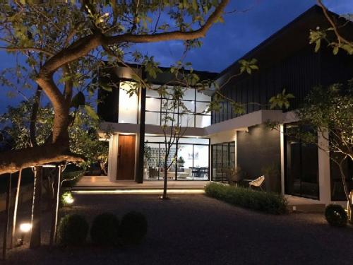a house with a glass facade at night at THE OAK’S in Chiang Rai