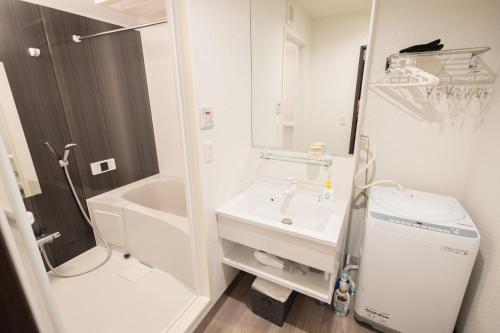 東京的住宿－“1ST ROOM” 内装デザイナー監修！30㎡ 最大6名 経堂駅から徒歩5分 築浅 良質な暮らしを，白色的浴室设有水槽和卫生间。