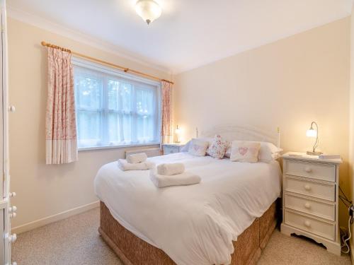 ein Schlafzimmer mit einem großen Bett und einem Fenster in der Unterkunft Bramble Cottage-uk45596 in Verwick