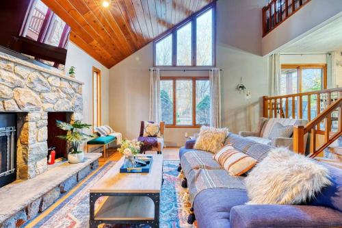 a living room with a blue couch and a stone fireplace at Antler Ridge: 3BDR w Hot Tub & Game Room in Albrightsville