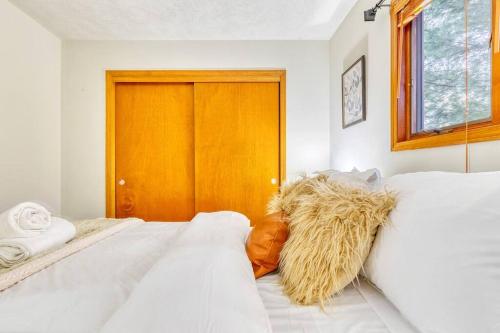 a bedroom with two white beds and a wooden door at Antler Ridge: 3BDR w Hot Tub & Game Room in Albrightsville