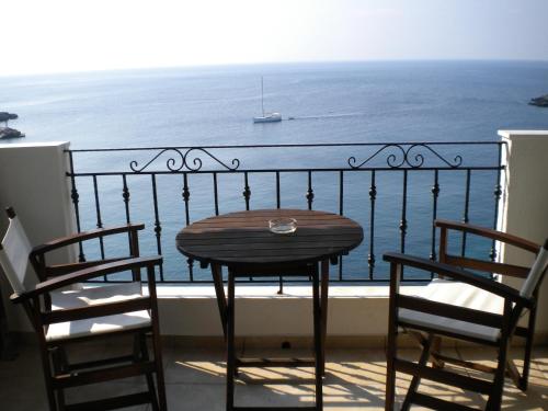 a table and chairs on a balcony with the ocean at Yalis Hotel in Votsi